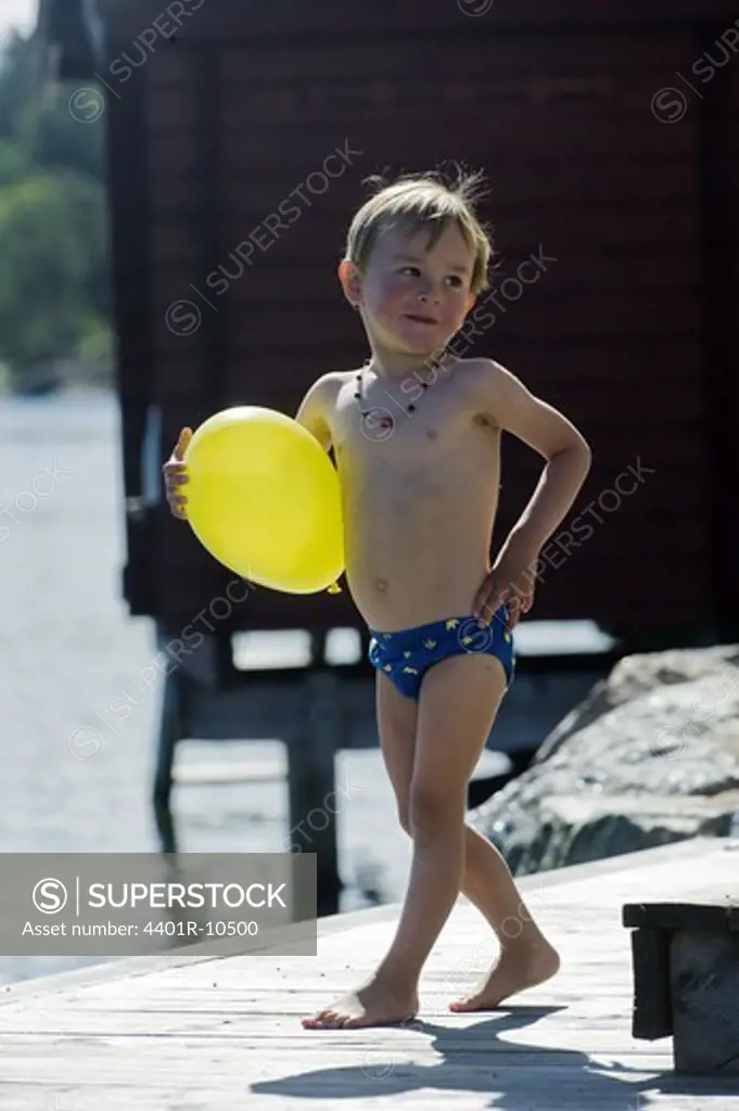 Portrait of a boy holding a yellow balloon, Stockholm archipelago, Sweden.