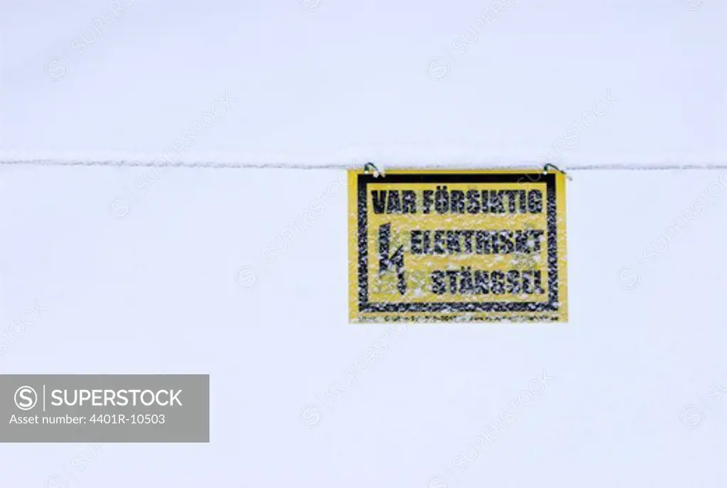 A warning sign covered in snow, Sweden.