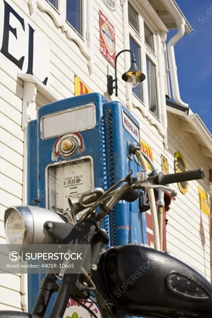 Petrol pump and a motorcycle in front of a country shop, Norway.