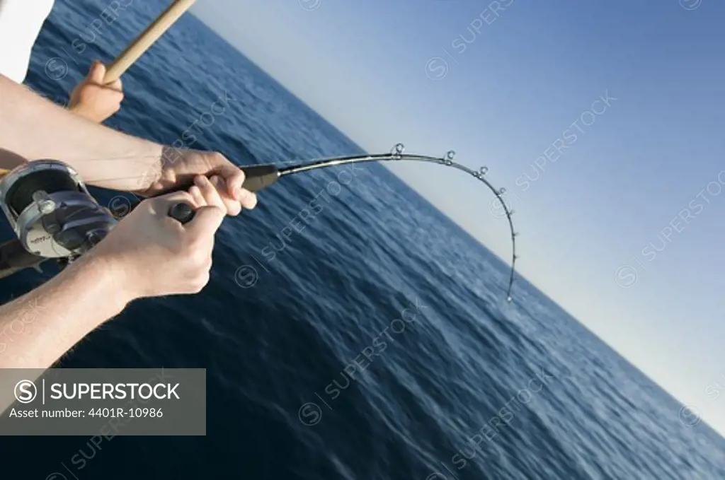 Hands holding a casting rod