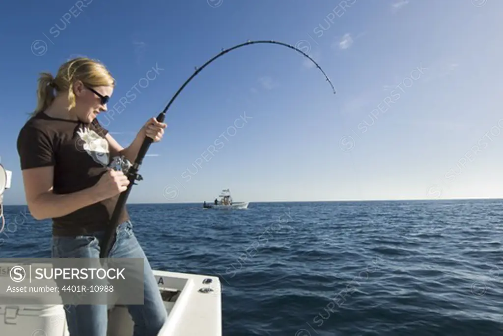 Woman fishing from a boat