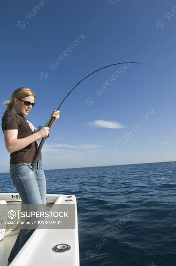 Woman fishing on a boat