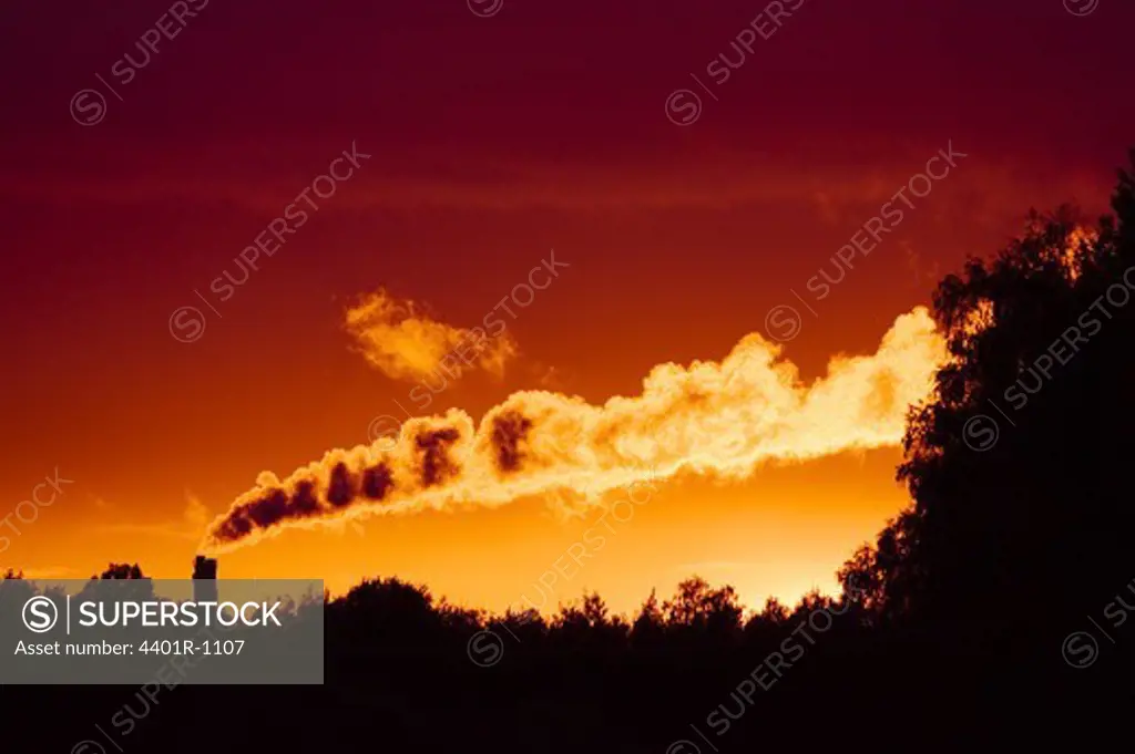 Smoke from a factory in the sunset.