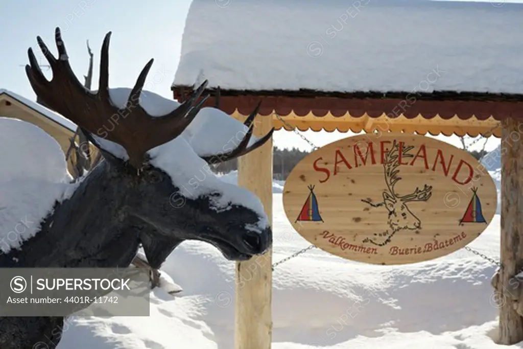 Scandinavia, Sweden, Harjedalen, Vemdalen, Snow covered statue of elk and signboard, close-up