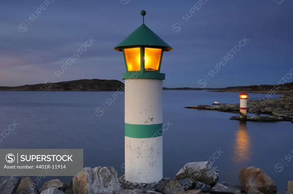 Scandinavia, Sweden, Vastkusten, View of illuminated lighthouse on sea