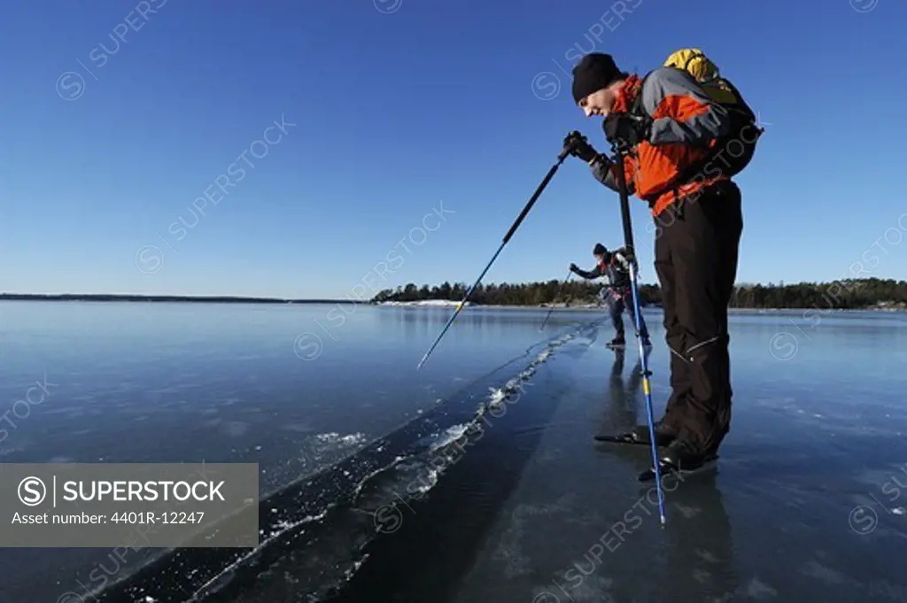 Skaters checking cracks in the ice