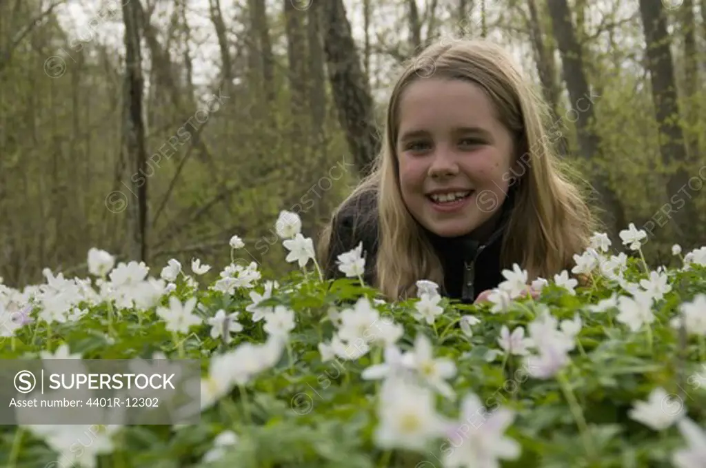 Scandinavia, Sweden, Smaland, Girl with white anemones in foreground, smiling, portrait