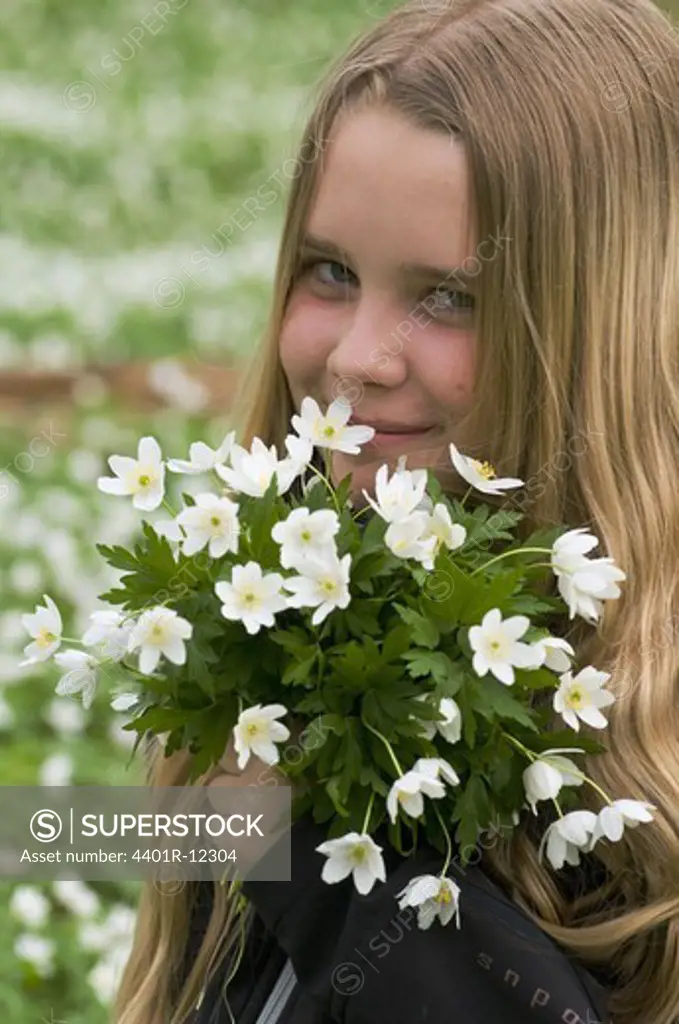 Scandinavia, Sweden, Smaland, Girl holding bunch of white anemones, portrait, close-up