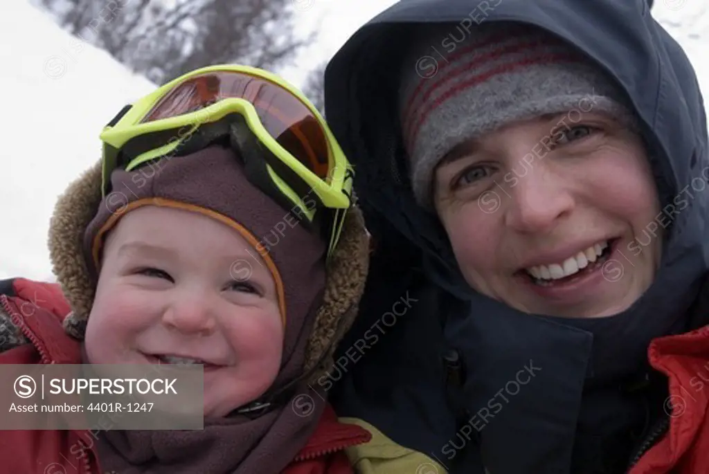 A smiling mother with a child a winter day, Sweden.