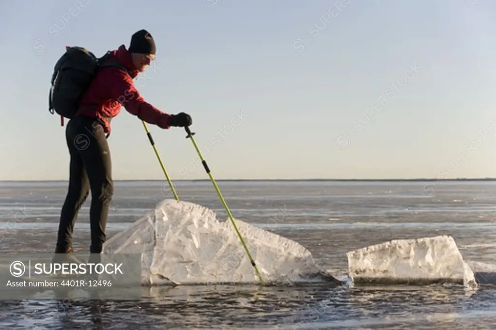 Man skating on frozen lake and looking at ice floe