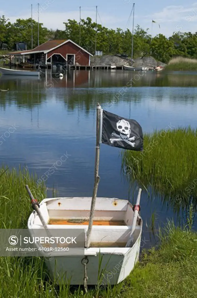 Flag with skull and crossbones on boat next to sea