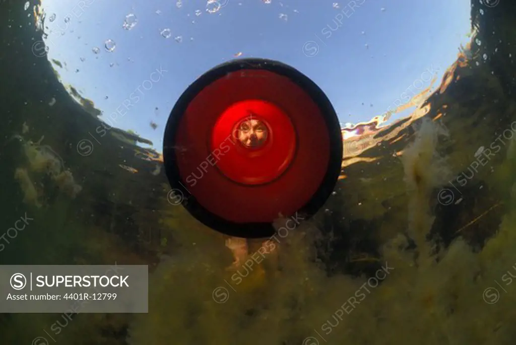 Woman looking through optical equipment into water