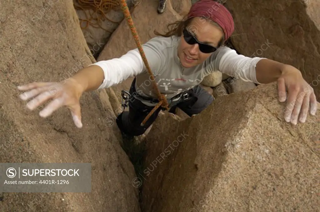 Female ecotourist Rock Climbing, Sweden.