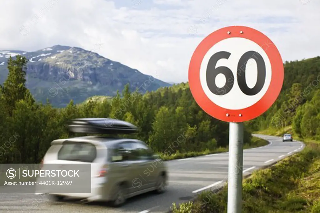 Car passing speed limit sign