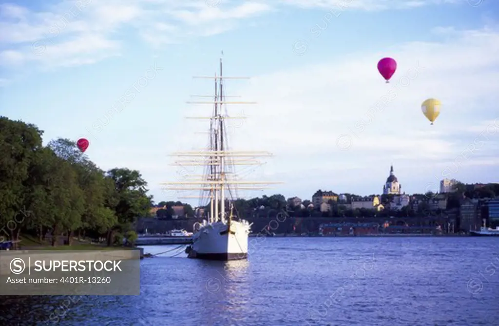 Sailing ship and hot air balloons, Stockholm skyline in background