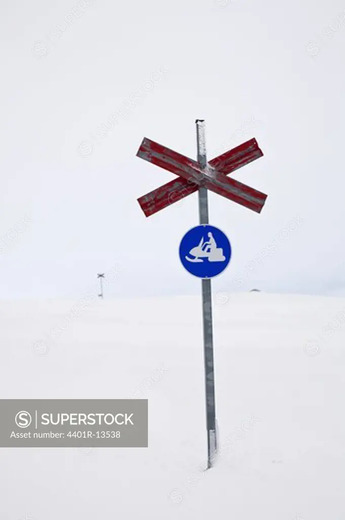 Sign post with cross on snow covered mountain