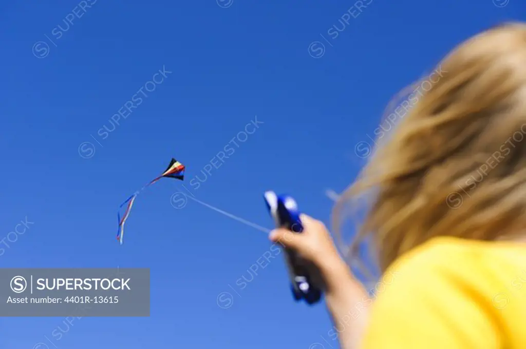 Over the shoulder view of child flying kite