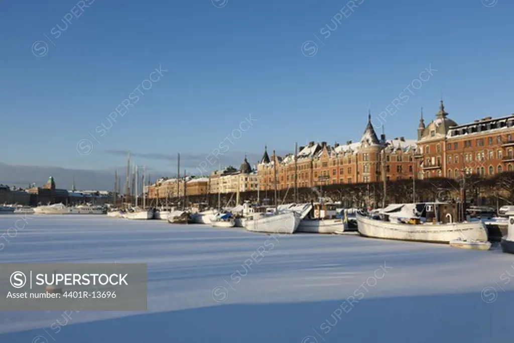 Frozen river in city during winter
