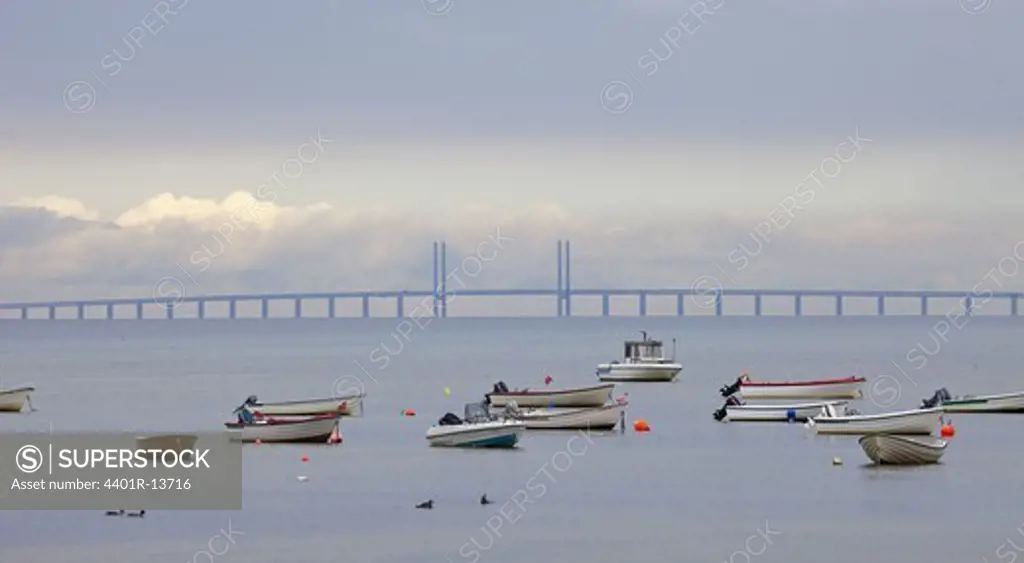 View of fishing boats on sea with bridge in background