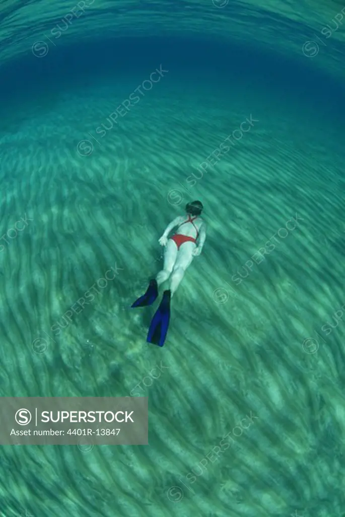 Woman free diving under sea