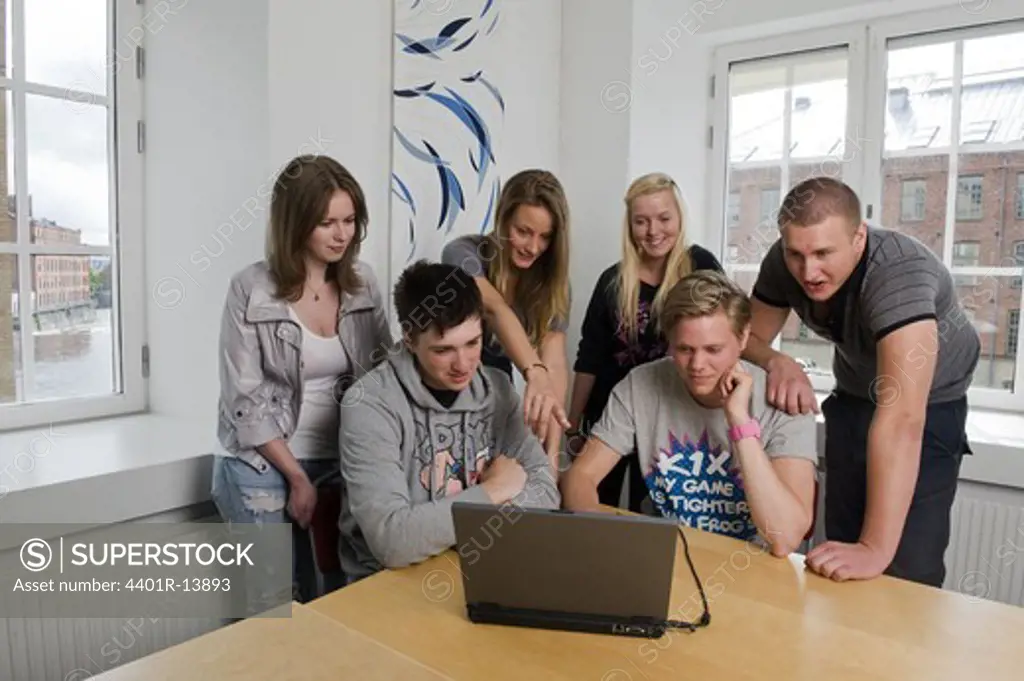 Students looking at laptop in classroom