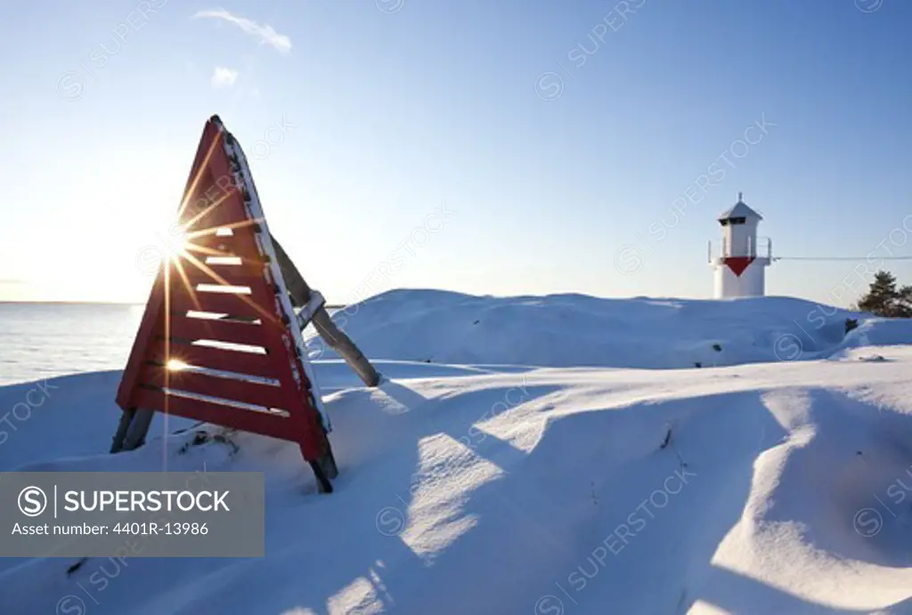 Snow covered landscape with lighthouse