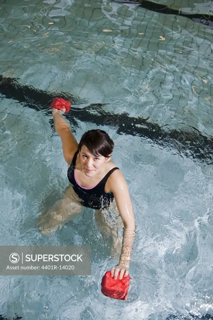 Young woman exercising in swimming pool