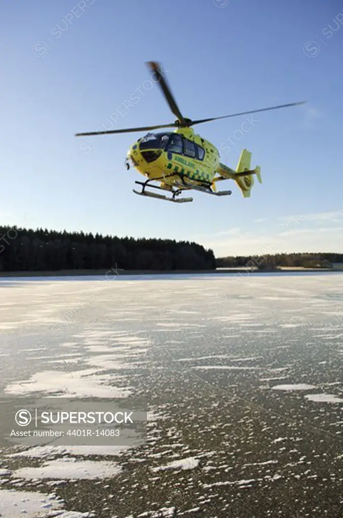 Medical rescue helicopter flying over frozen river