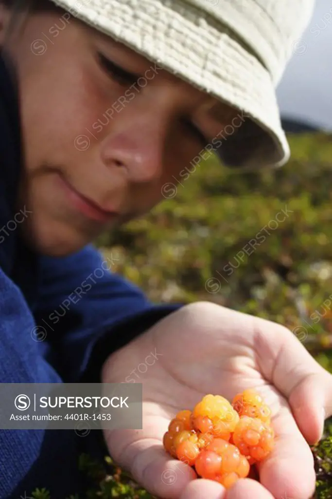 A boy with cloudberries in his hand, Sweden.
