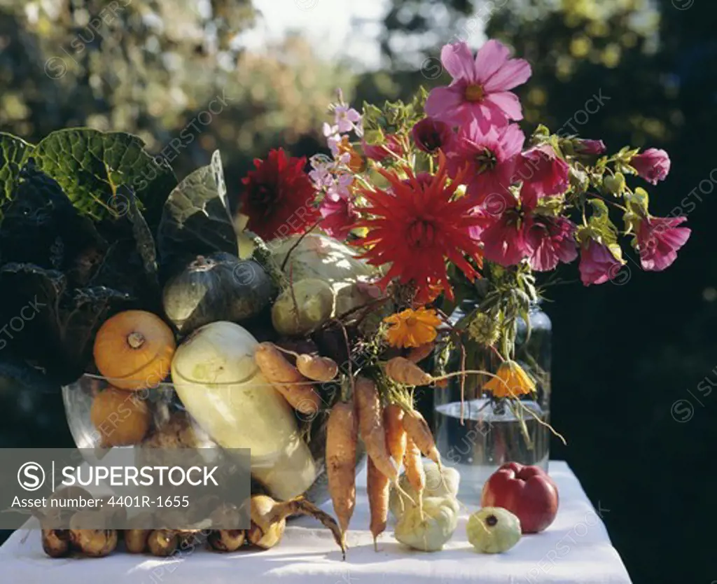 Containers filled with fruits and flowers lying on table