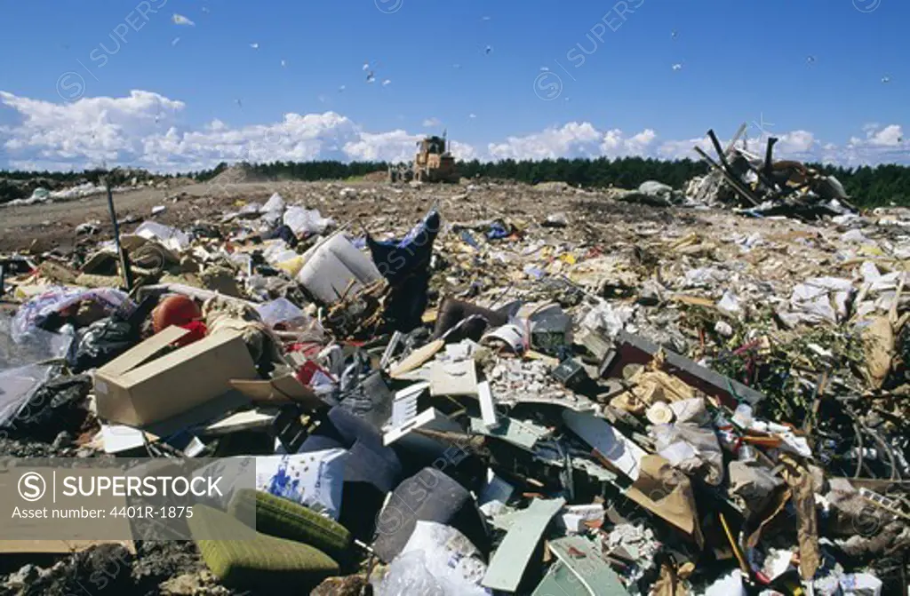 Garbage dump with bulldozer in background
