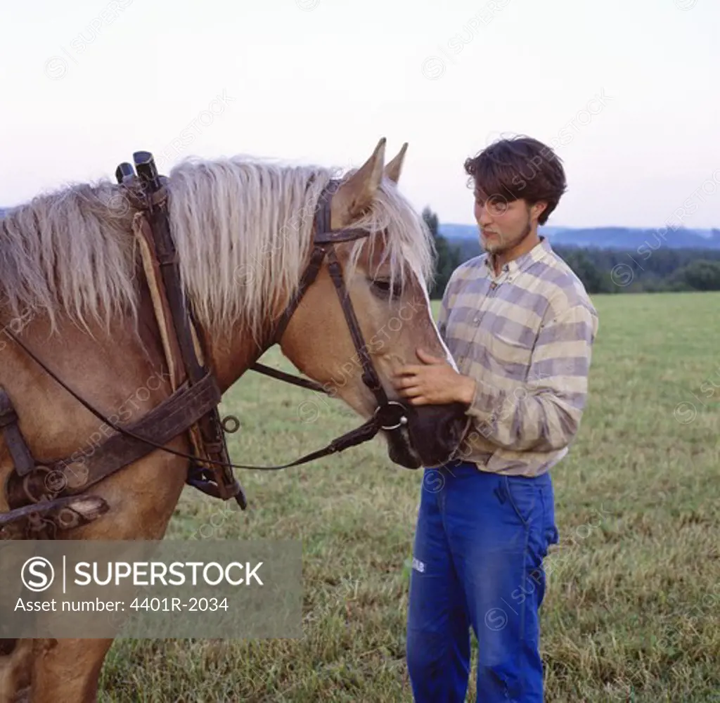 Man standing with horse in field