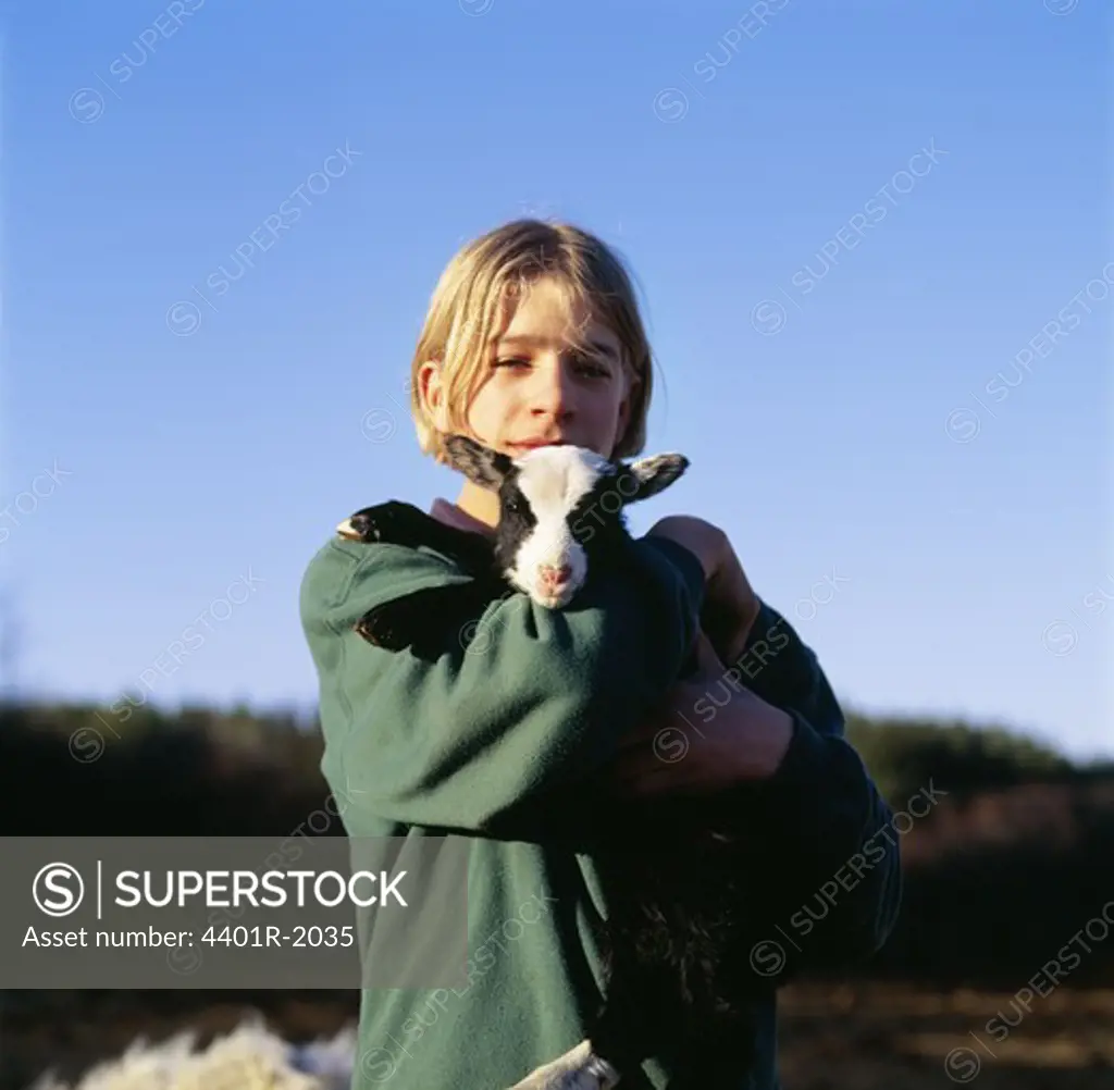 Teenager girl holding lamb