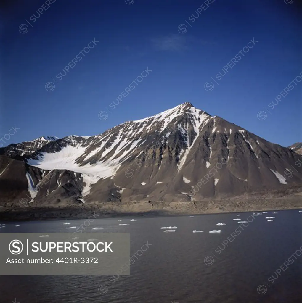 Snow-covered mountain by river