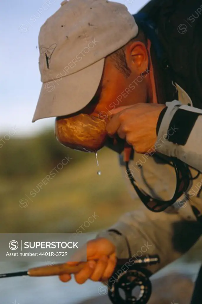 Fly fisherman drinking the rivers clean water