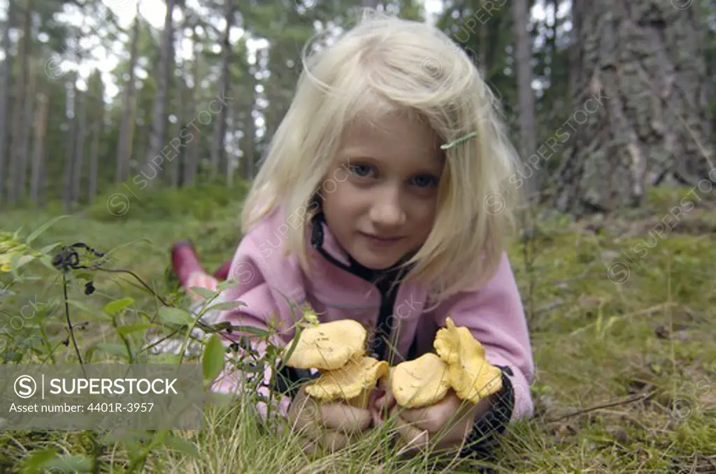 A girl holding chanterelles, Sweden.