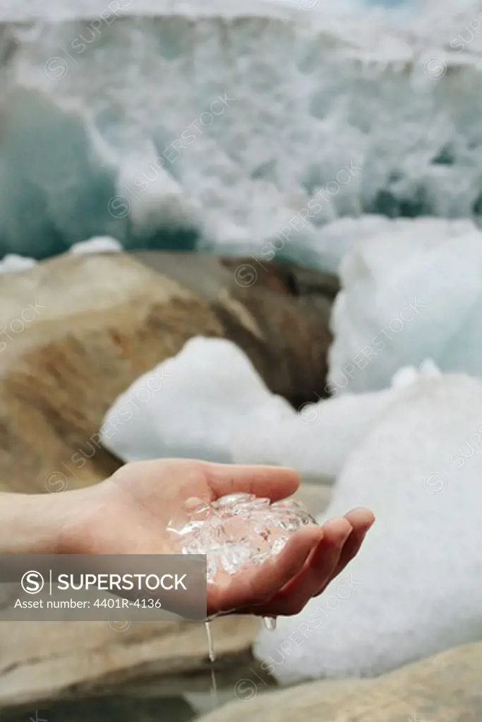 A hand holding melting ice, Norway.