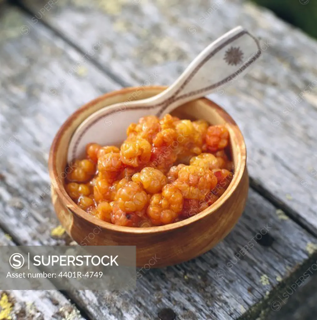 Cloudberries in a cup with a spoon made of reindeer horn, Lapland, Sweden.