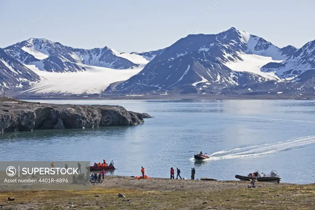 Tourists by a fjord in Svalbard, Norway.