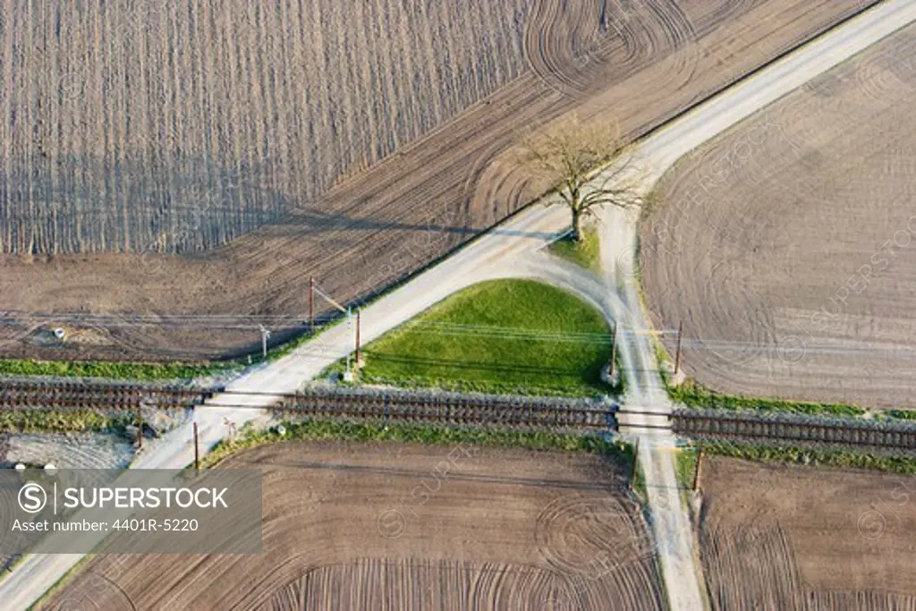 Gravelled roads in agricultural district and a railway, aerial view, Skane.