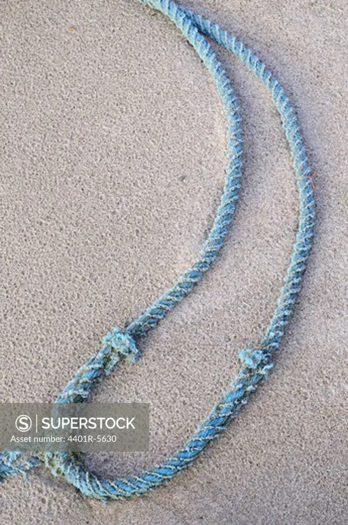A blue rope on the beach.