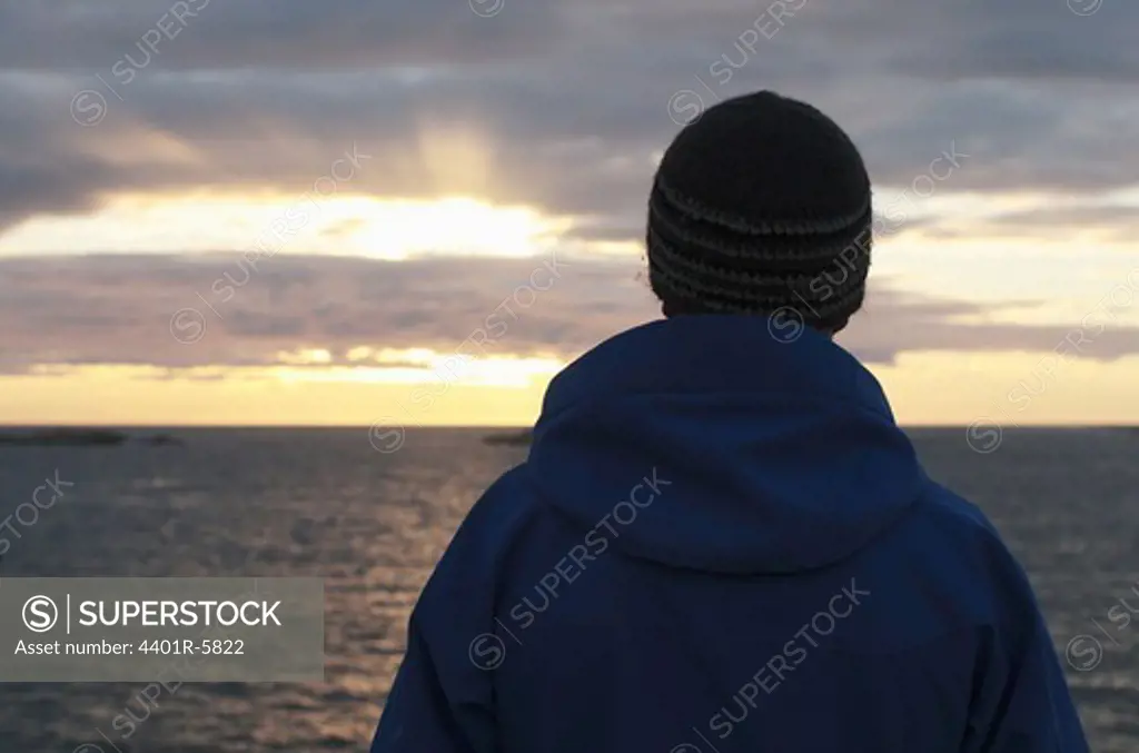 A man standing by the ocean, Bohuslan, Sweden.
