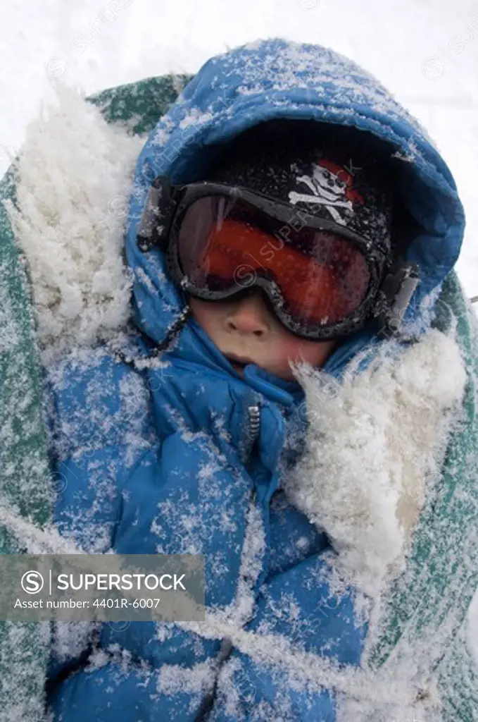 A sleeping child in a little sledge.