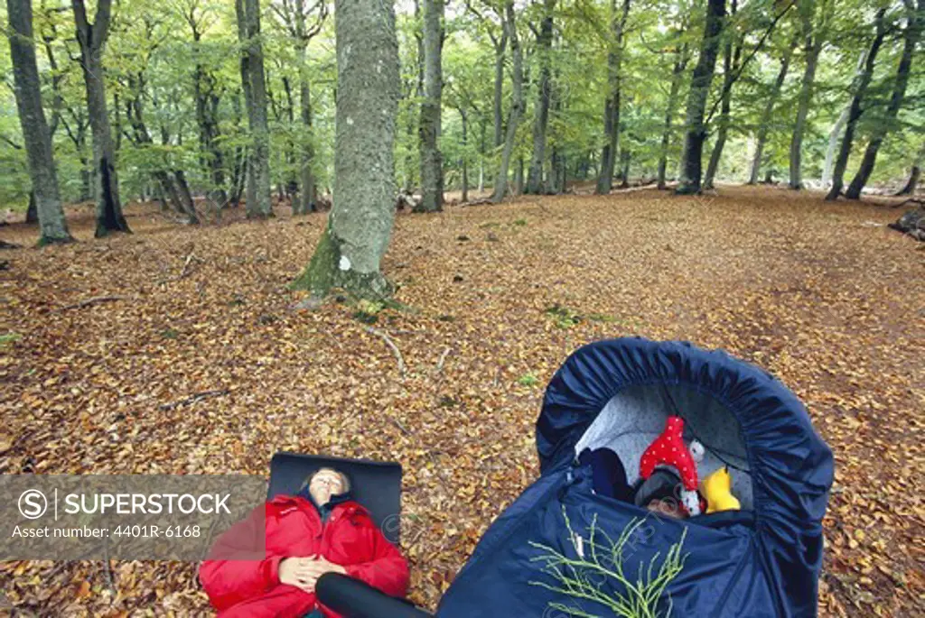 Mother and baby taking a nap in the forest, Sweden.