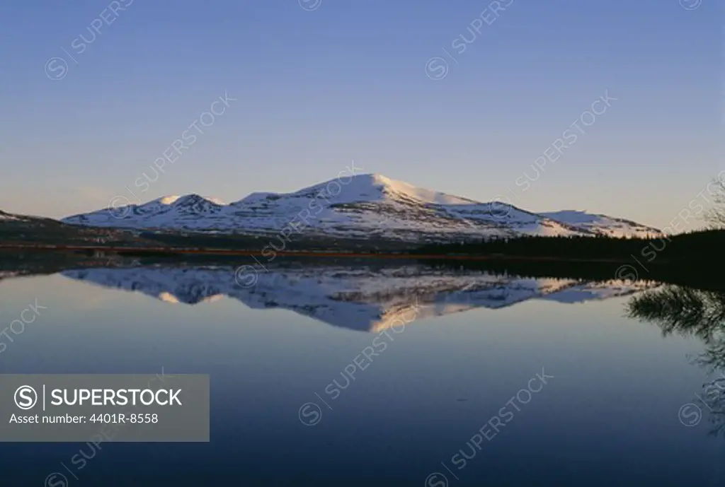 Snowcapped mountains reflecting in water