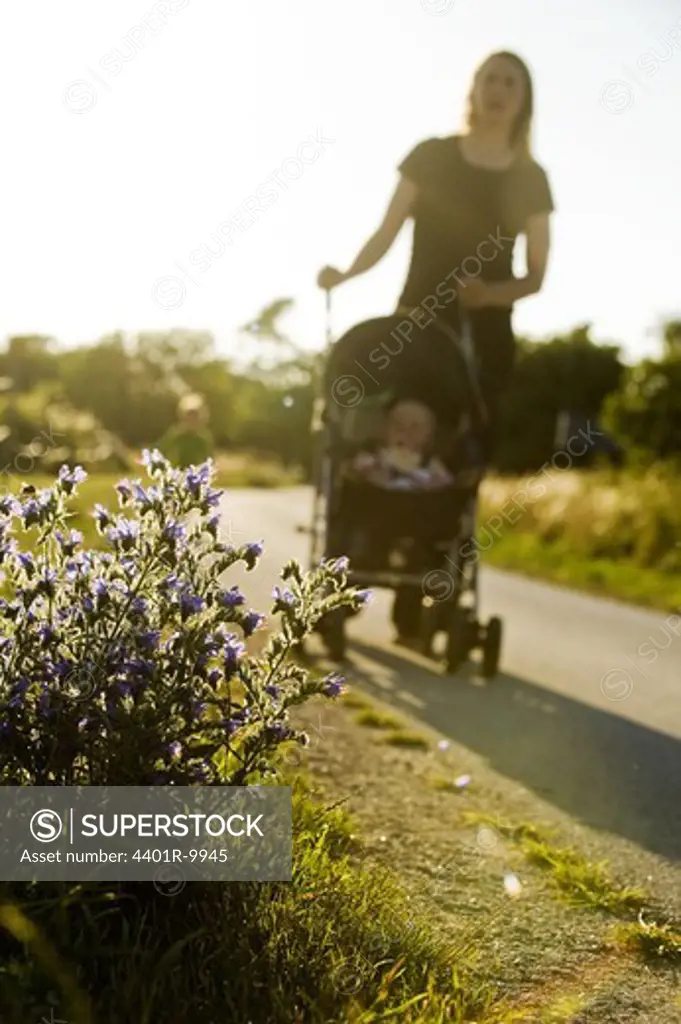 A woman with a stroller against the light, Sweden.