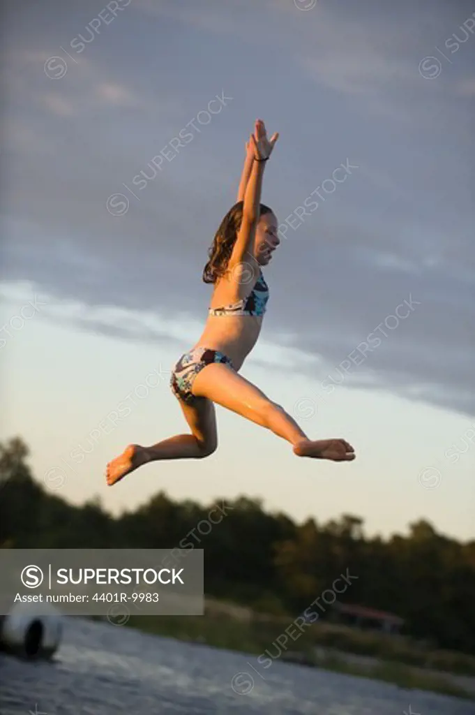 A girl jumping into the water, Sweden.