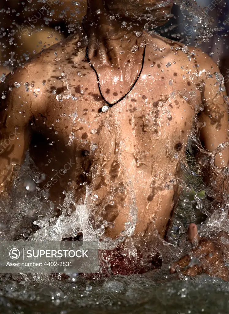 Young male Hindu devotee bathing in the Ganges, Varanasi, India