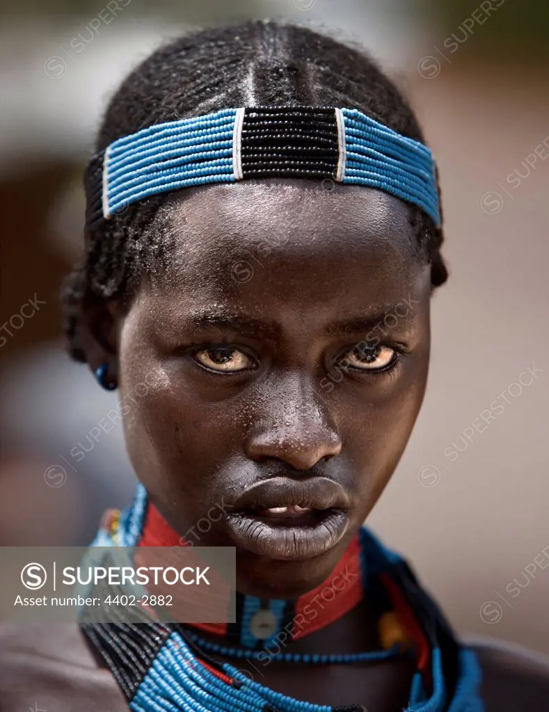 Girl from the Hamar tribe wearing traditional bead headdress and necklaces, Dimeka market, Omo Delta, Ethiopia, Africa.
