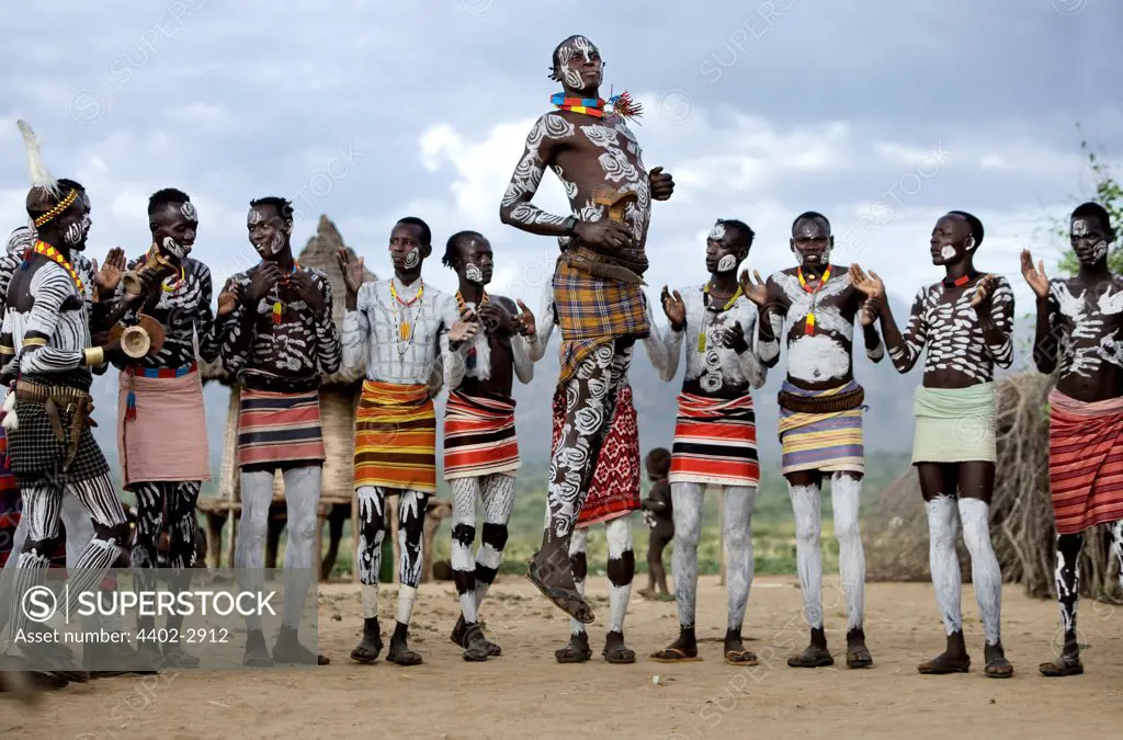 Karo tribesman with traditional clay body decoration, taking turns to dance in the circle. Omo Delta, Ethiopia, Africa.